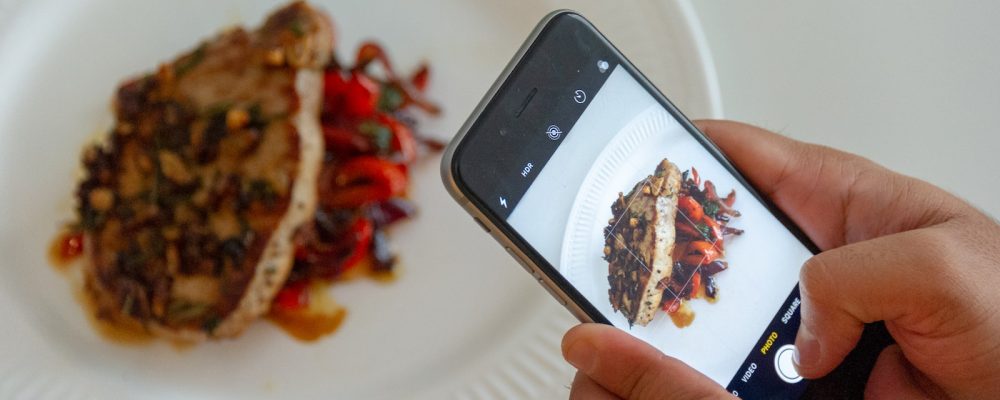 person taking picture of plated food