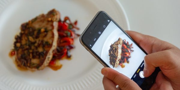 person taking picture of plated food
